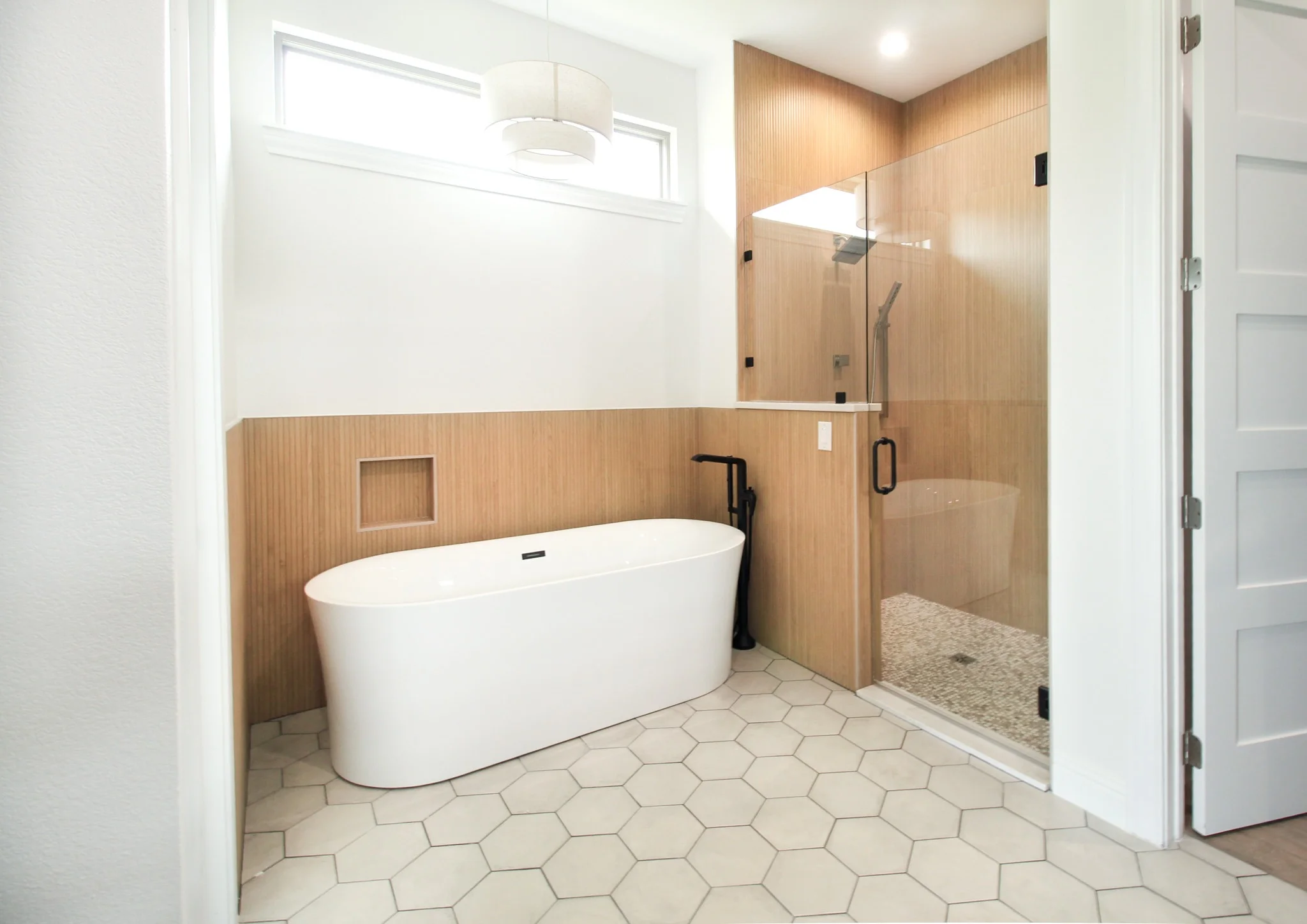 Master bathroom in a whole house renovation in Azle, TX with a free-standing tub and hexagon flooring